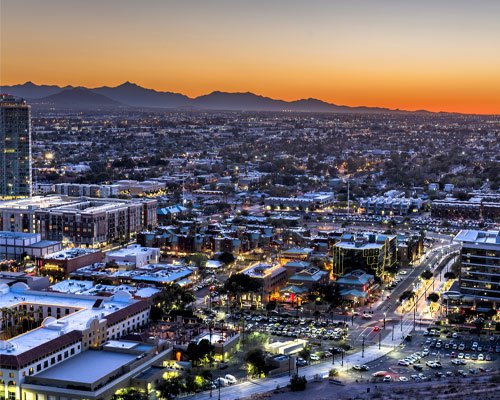 Tucson city skyline at sunset, showcasing urban landscape and mountains, relevant to Luna Pool Service's local pool maintenance and repair offerings.